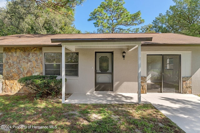 entrance to property with a porch and a yard