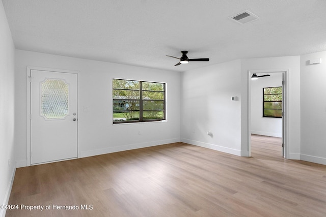 interior space featuring a textured ceiling, light wood-type flooring, and ceiling fan