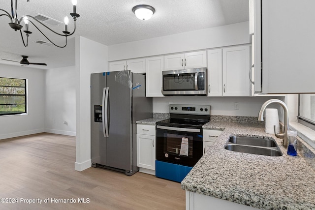 kitchen featuring light hardwood / wood-style floors, white cabinets, a textured ceiling, sink, and appliances with stainless steel finishes