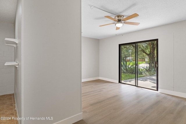 empty room with light wood-type flooring, a textured ceiling, and ceiling fan