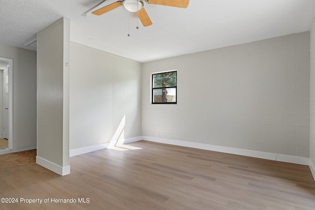 unfurnished room featuring ceiling fan, a textured ceiling, and light wood-type flooring