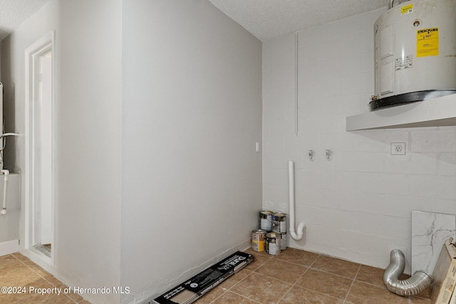 laundry room with water heater, a textured ceiling, light tile patterned floors, and hookup for an electric dryer