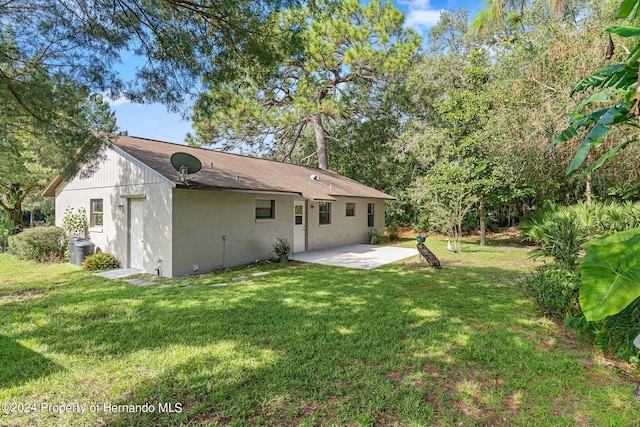 rear view of property featuring a lawn and a patio