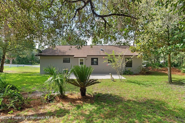 rear view of house with a yard and a patio