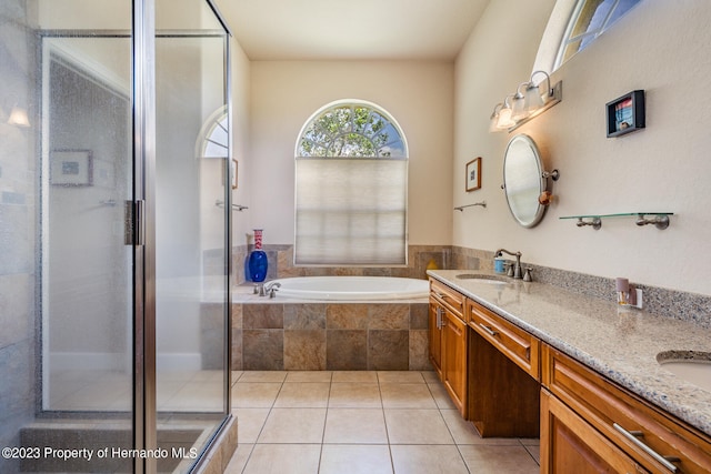 bathroom with vanity, tile patterned flooring, and plus walk in shower