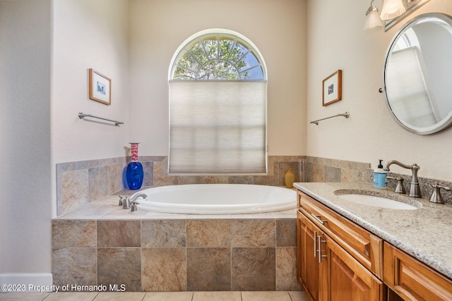 bathroom featuring vanity, tile patterned floors, and tiled tub