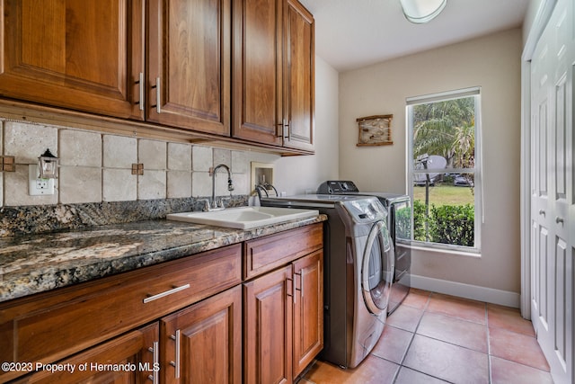 clothes washing area featuring cabinets, sink, independent washer and dryer, and light tile patterned floors