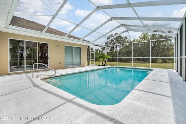 view of swimming pool with glass enclosure and a patio