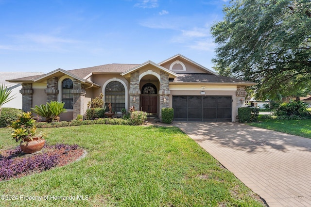 ranch-style house with a garage and a front lawn