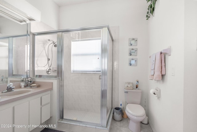 bathroom with walk in shower, vanity, tile patterned floors, and toilet