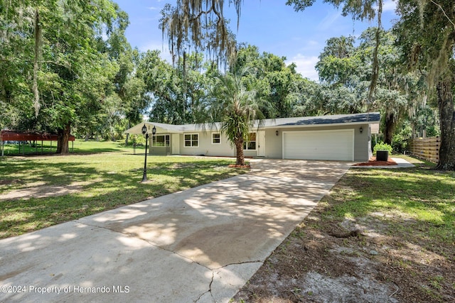 ranch-style house featuring a garage and a front lawn