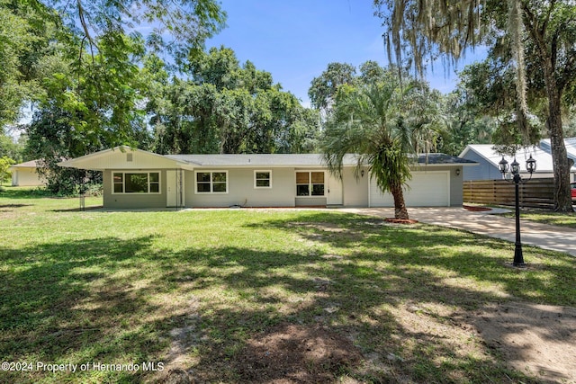 ranch-style house featuring a front yard and a garage