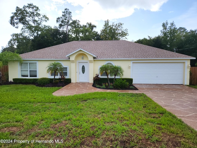 single story home with a garage and a front lawn