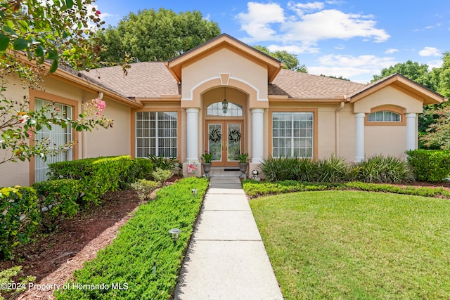 doorway to property featuring french doors and a yard