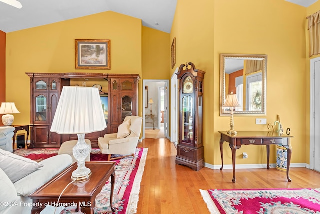 living room with light wood-type flooring and vaulted ceiling