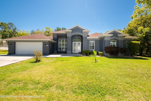 view of front of home featuring french doors, a front lawn, and a garage