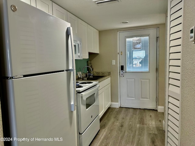 kitchen featuring light wood-type flooring, white appliances, sink, and white cabinets