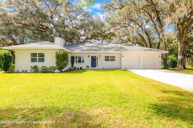 ranch-style home with a garage and a front lawn