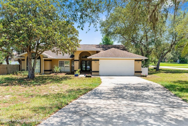 view of front facade with a garage, french doors, and a front yard