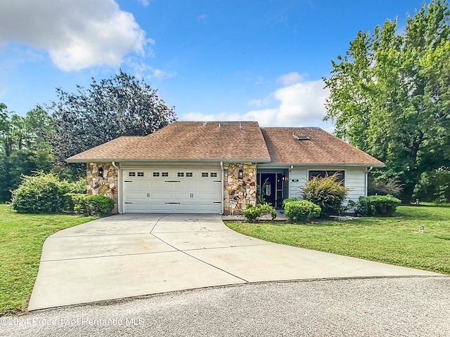 ranch-style house featuring a garage and a front lawn