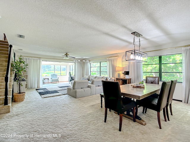 dining area with ceiling fan, a textured ceiling, and light colored carpet