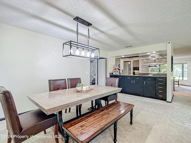 dining space with a textured ceiling and sink