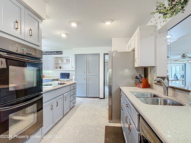 kitchen featuring a textured ceiling, gray cabinets, stainless steel appliances, and sink