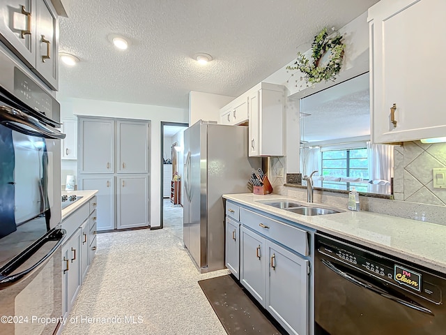 kitchen with a textured ceiling, black appliances, sink, and backsplash