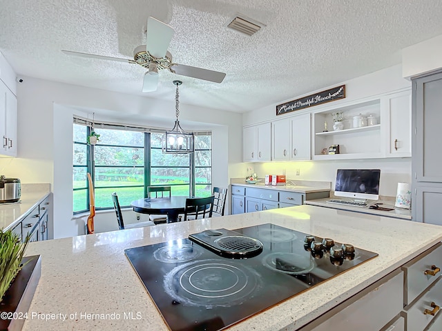 kitchen with white cabinets, a textured ceiling, and black electric cooktop