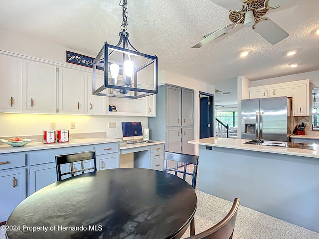 kitchen featuring white cabinetry, decorative light fixtures, a textured ceiling, stainless steel refrigerator with ice dispenser, and ceiling fan with notable chandelier