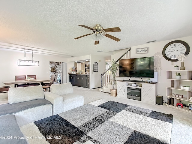 living room with ceiling fan and a textured ceiling