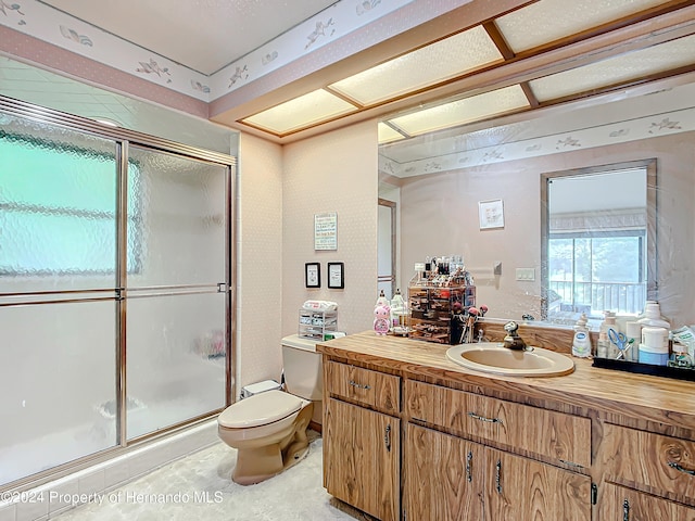 bathroom with walk in shower, vanity, and toilet