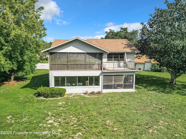 back of property featuring a sunroom and a yard