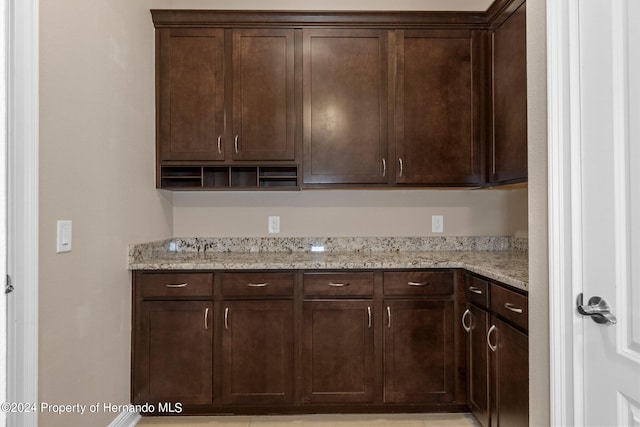 kitchen with dark brown cabinetry and light stone counters