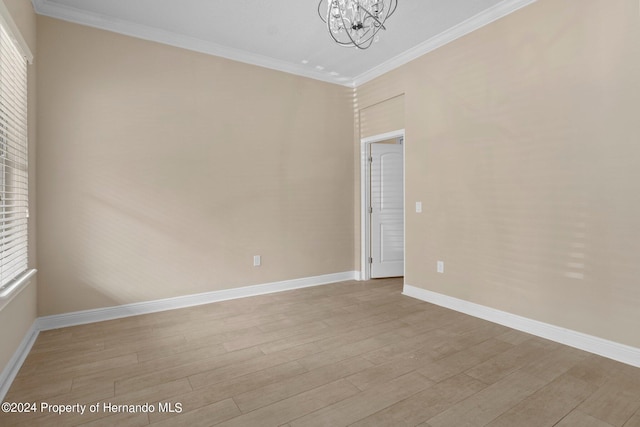 unfurnished room featuring light hardwood / wood-style floors, a notable chandelier, and ornamental molding