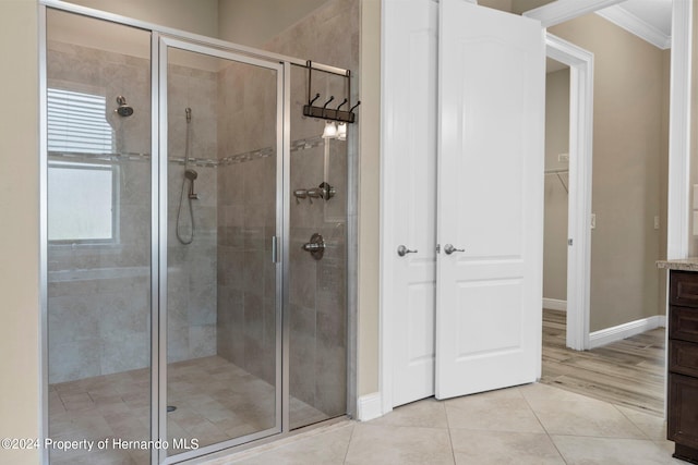 bathroom with walk in shower, tile patterned flooring, vanity, and crown molding