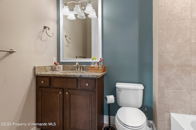 bathroom featuring toilet, a tub to relax in, and vanity