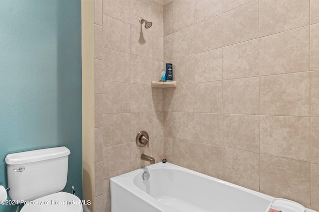 bathroom featuring tiled shower / bath and toilet