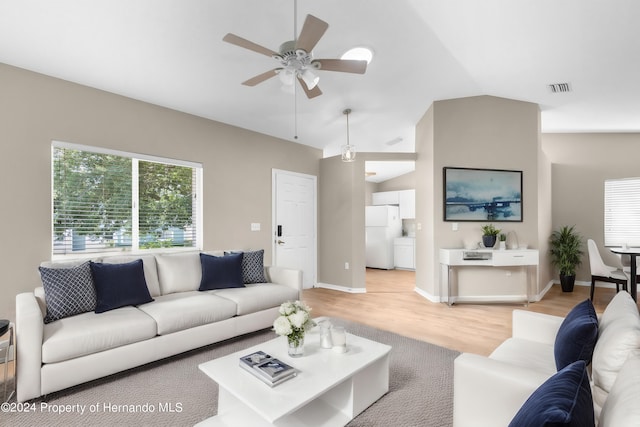 living room with ceiling fan, light hardwood / wood-style flooring, and vaulted ceiling