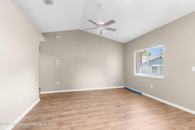 empty room with ceiling fan, light hardwood / wood-style flooring, and vaulted ceiling