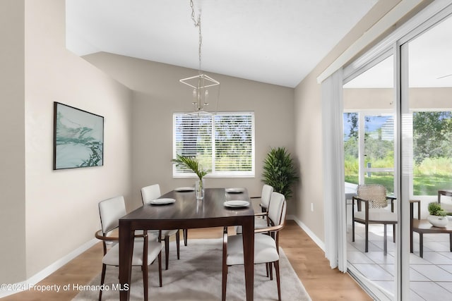 dining room with light hardwood / wood-style floors, plenty of natural light, and lofted ceiling