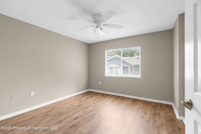 spare room featuring wood-type flooring, a textured ceiling, and ceiling fan