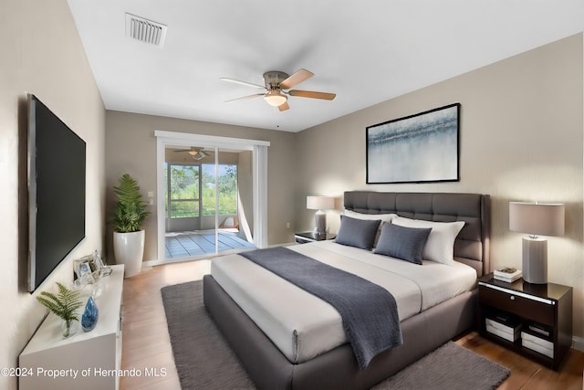 bedroom with access to exterior, hardwood / wood-style floors, and ceiling fan