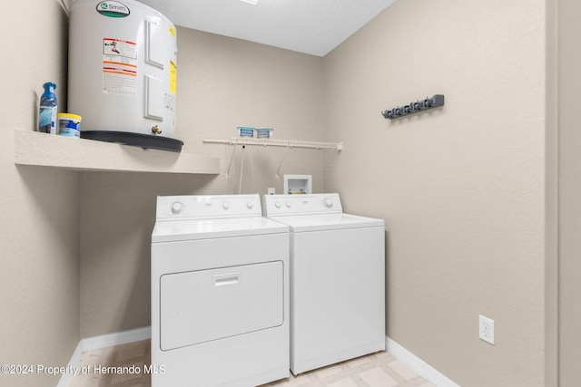 washroom featuring electric water heater and washer and clothes dryer