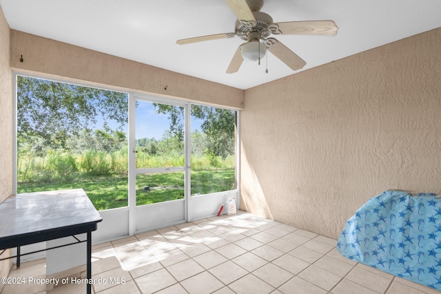 sunroom featuring ceiling fan and a healthy amount of sunlight