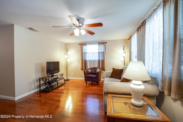 living room featuring a textured ceiling, hardwood / wood-style flooring, and ceiling fan