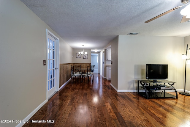 interior space featuring dark wood-type flooring, a chandelier, and a textured ceiling