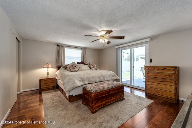 bedroom featuring access to exterior, a textured ceiling, dark wood-type flooring, and ceiling fan