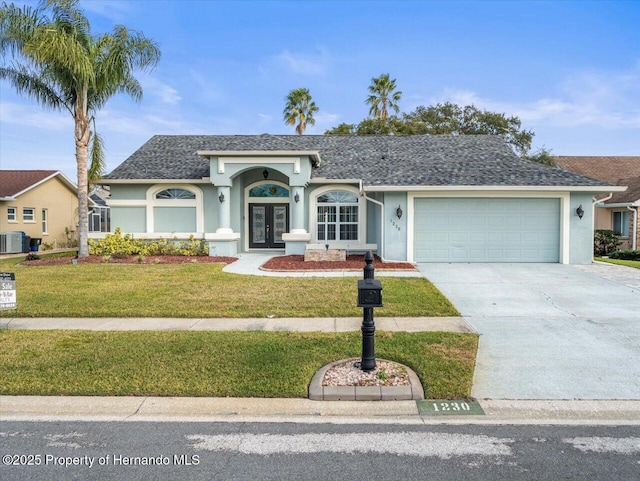 ranch-style home with central AC unit, a garage, a front lawn, and french doors