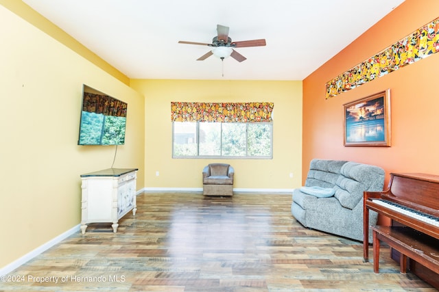 living area featuring wood-type flooring and ceiling fan